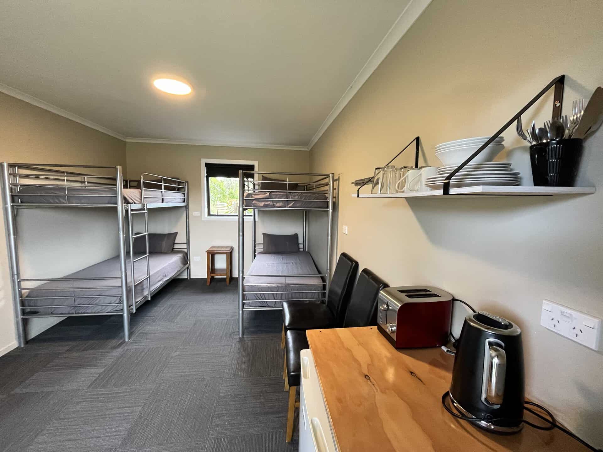 Tourist Bunk room showing 4 bunk beds and bench with toaster and jug